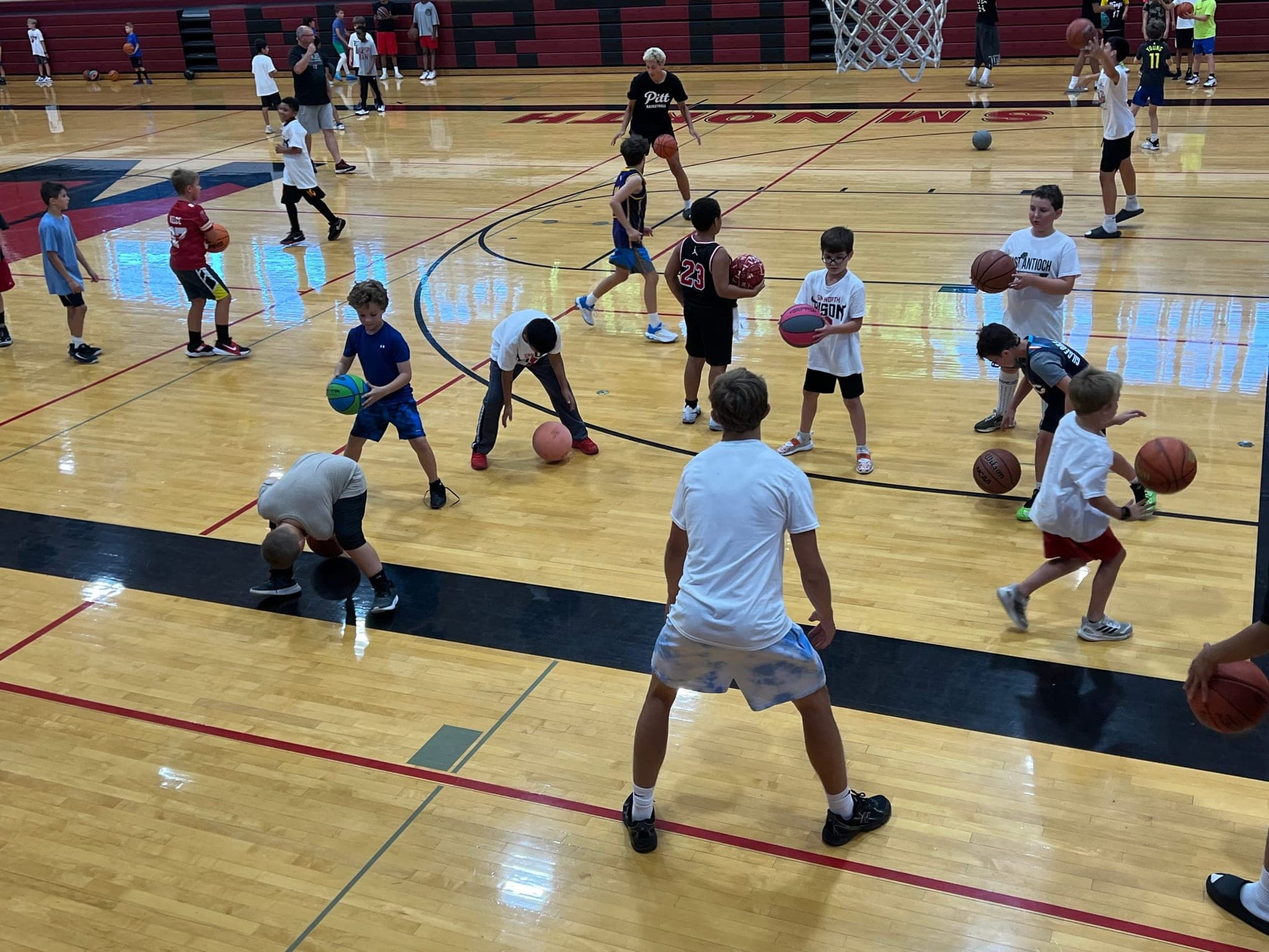 Young athletes running drills at a basketball camp