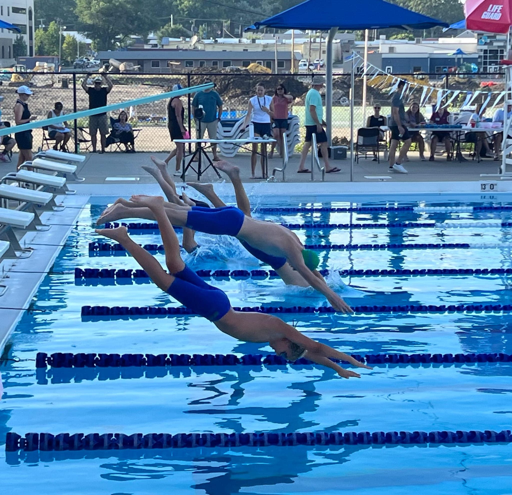 Swimmers diving off the blocks at a meet